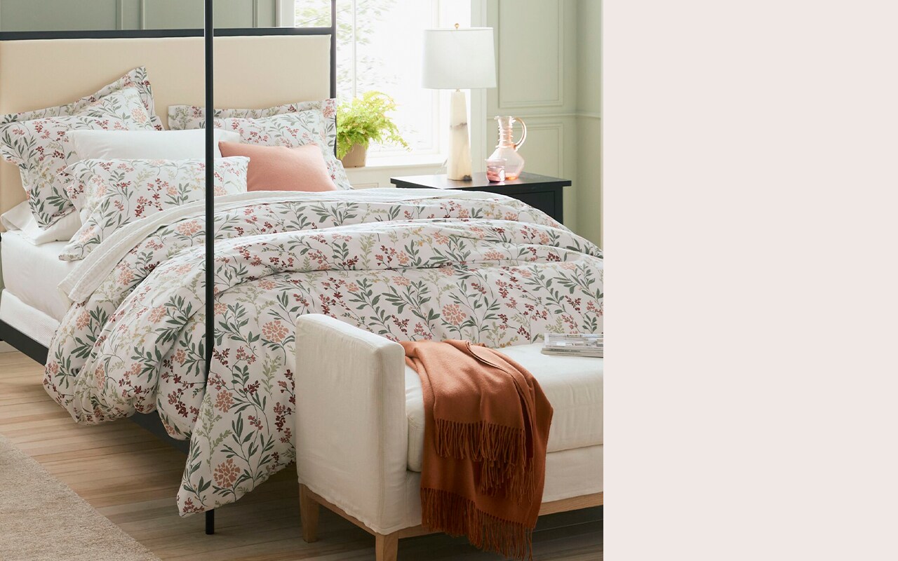 A bed with a wildflower patterned duvet cover and pillows. Shop bedding.