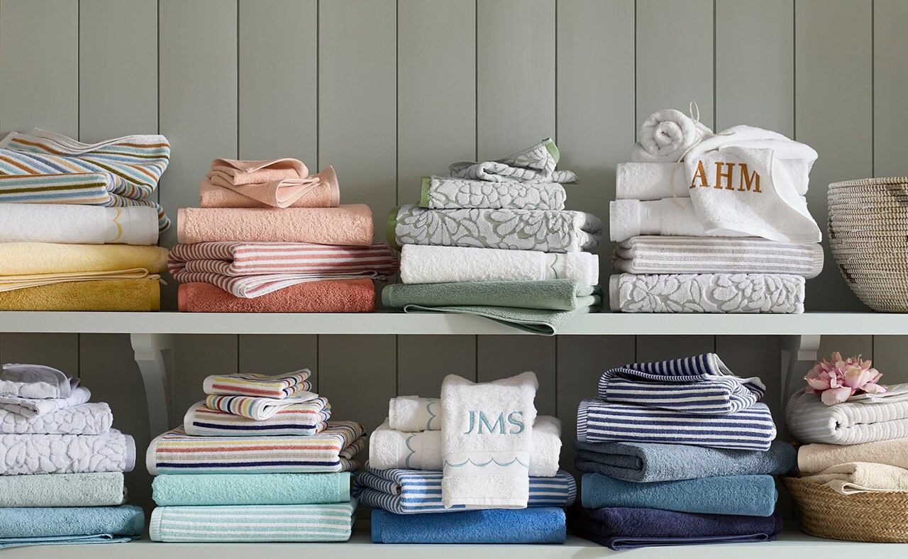 Stacks of colorful bath towels in various colors and prints. Shop towels.