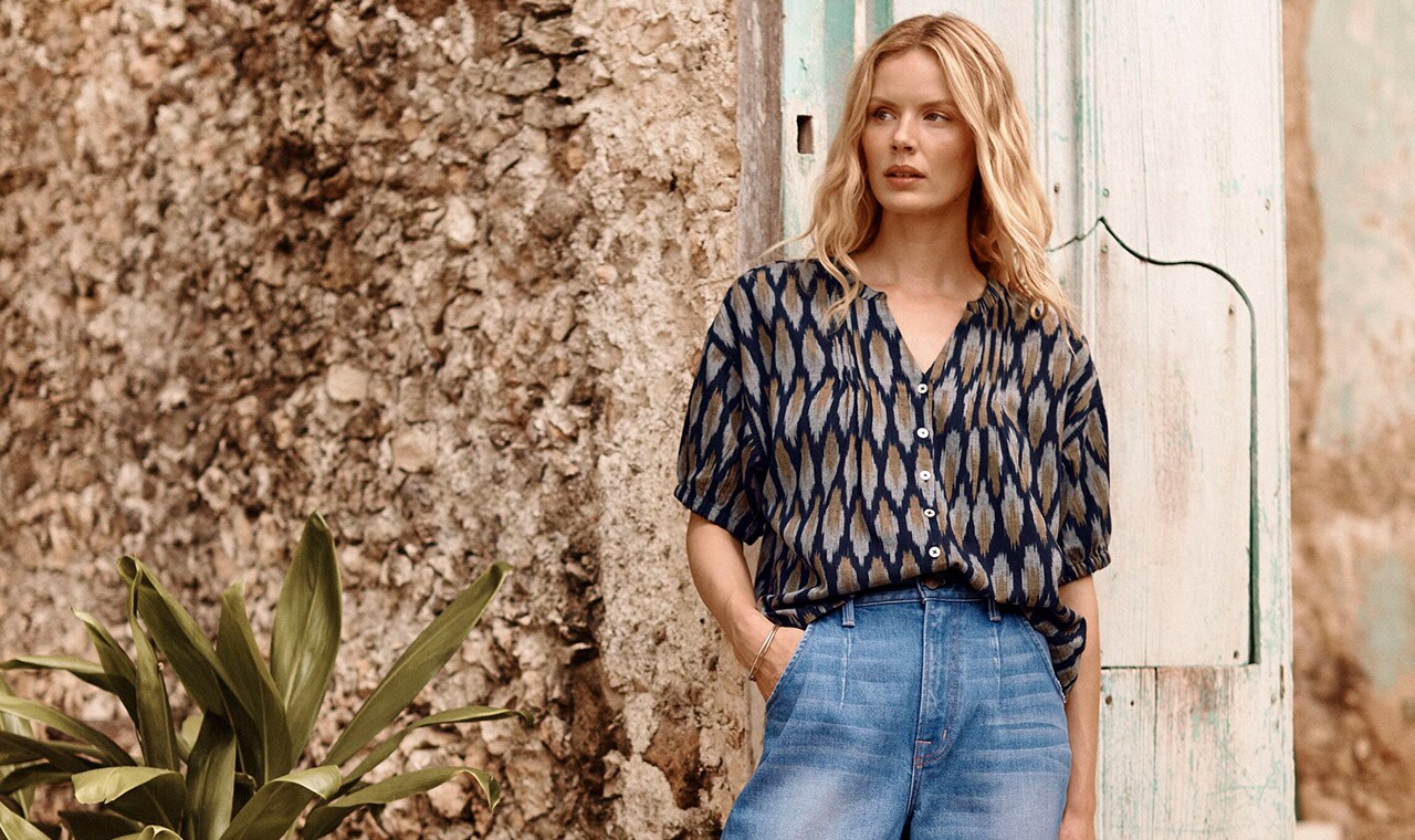 A woman in our Uma Ikat Button-Front Blouse. Explore our Wabi-Sabi Collection of women's clothing.