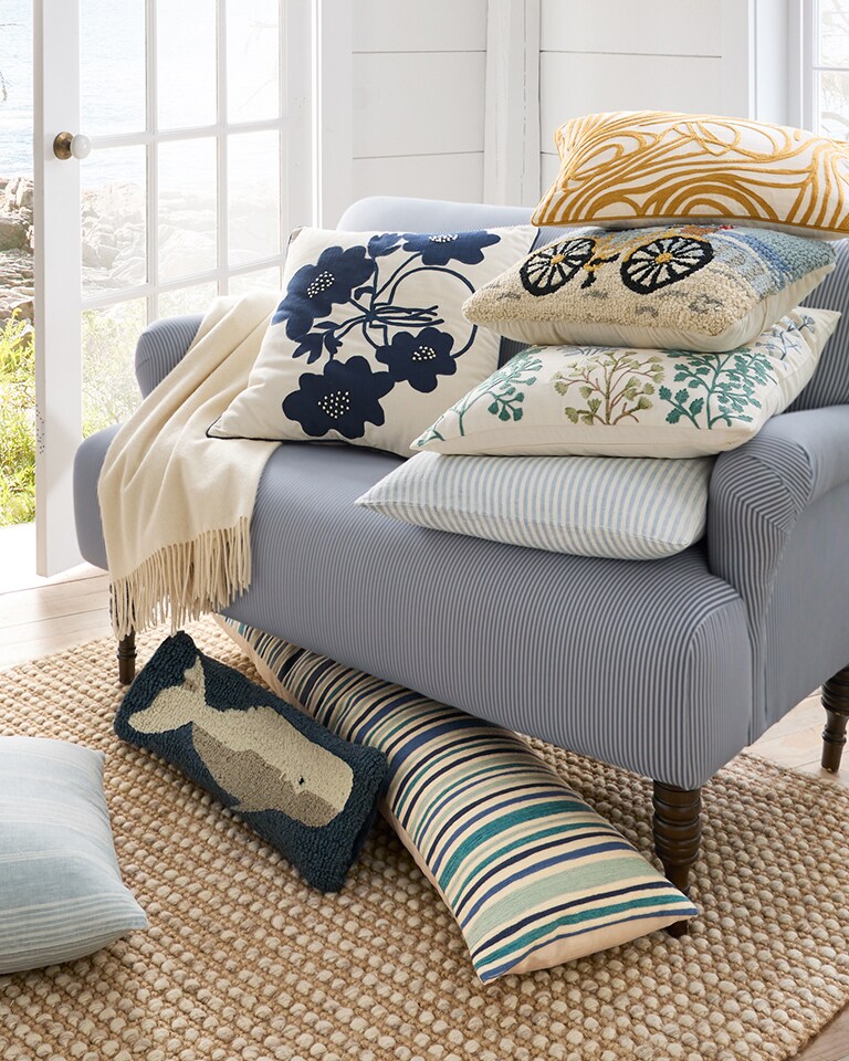 A couch with seasonal throw pillows in various patterns and colors. Shop pillow covers.