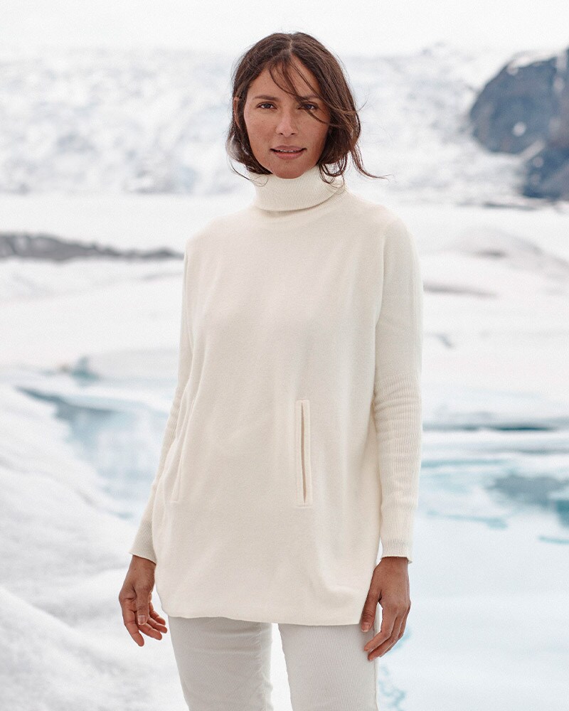 A woman in a white oversized turtleneck sweater. Browse women's gifts.